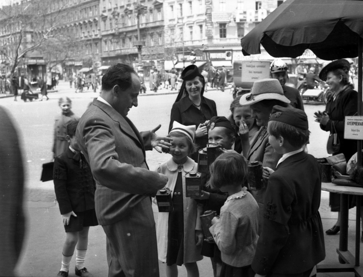 Bárdos Lajos karnagy adományt gyűjt 1942-ben az Oktogonon. A kapalos hölgy mögött látszanak a közlekedési lámpák Fotó: Fortepan/ képszám 71829) fortepan_71829.jpg